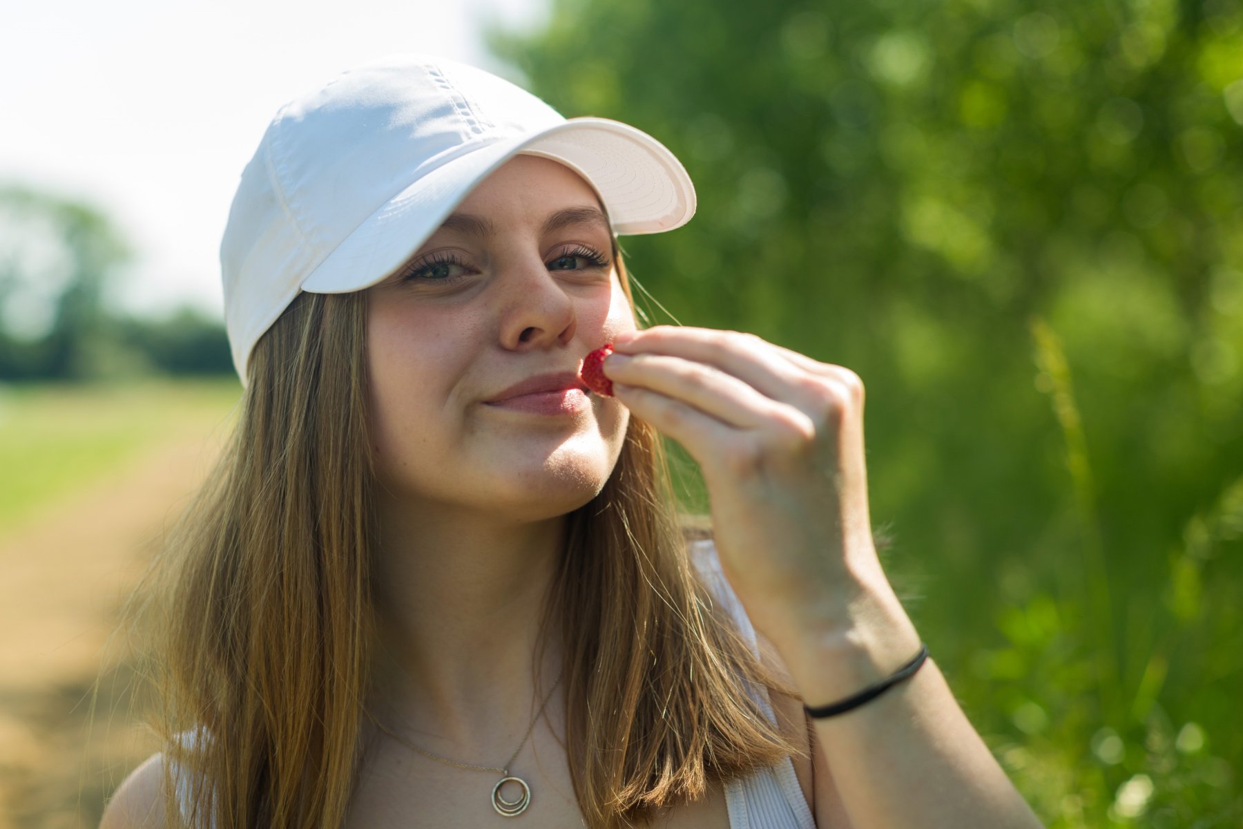 Eine Schülerin führt genüsslich eine Erdbeere zum Mund