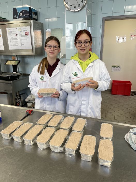 Zwei Schüler:innen in der Fleischverarbeitung beim Leberkäse verarbeiten
